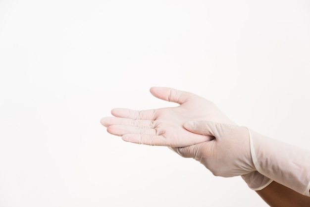 Mujer poniendo en mano guante de goma