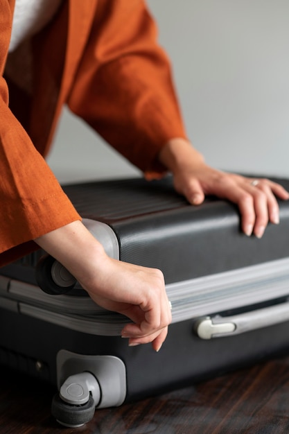 Foto mujer poniendo ropa en una maleta para sus vacaciones