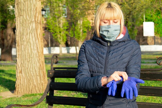 Mujer poniéndose guantes protectores contra el concepto Corona Virus