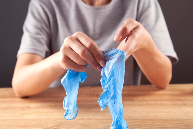 Mujer poniéndose guantes quirúrgicos de nitrilo azul