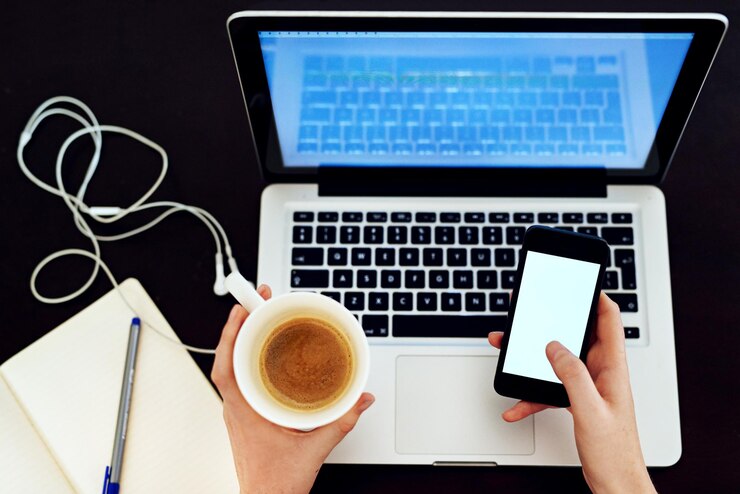Foto mujer portátil y café en vista superior para trabajo remoto con teléfono inteligente o portátil en fondo negro tecnología de creador de contenido y freelance desde arriba para maqueta de redes sociales y narración de marcas