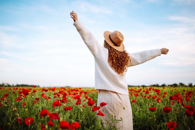 Mujer posando en un campo de amapolas