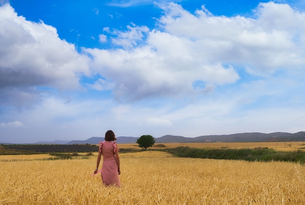 Mujer posando en campo de trigo.