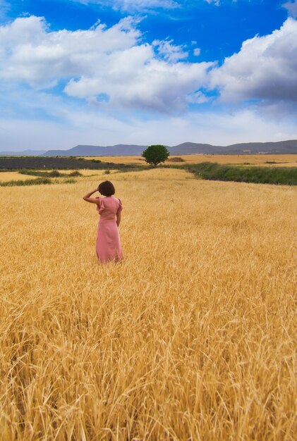 Mujer posando en campo de trigo.