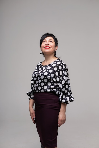 Mujer posando en el estudio sobre un fondo blanco en ropa de oficina