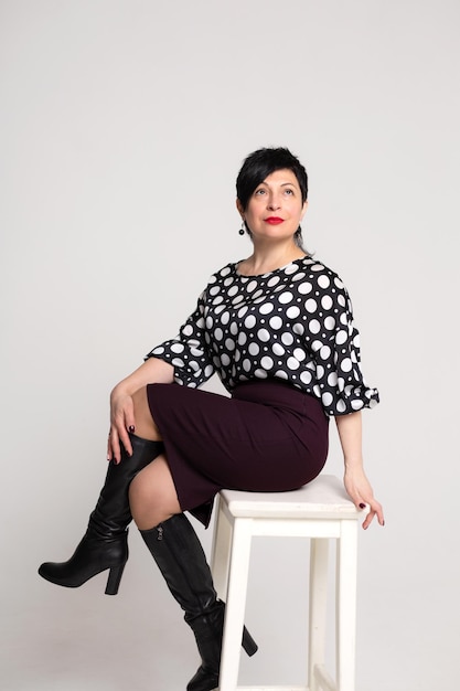 Mujer posando en el estudio sobre un fondo blanco en ropa de oficina