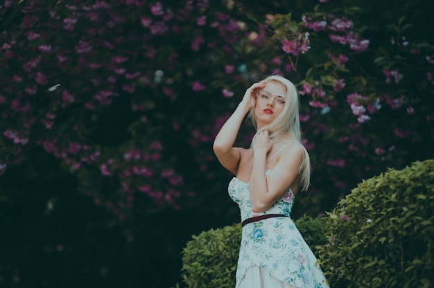 Mujer posando para una foto en un jardín