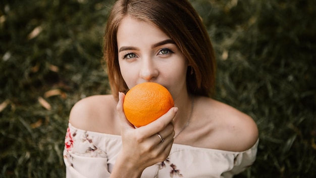 Mujer posando con naranja