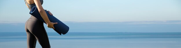 Mujer posando en ropa deportiva sobre fondo de cielo La parte media del cuerpo