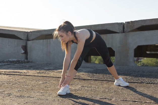 Mujer posando en ropa deportiva sobre fondo de cielo. La parte media del cuerpo.