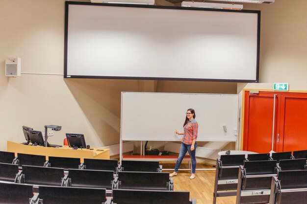 Mujer posando por el tablero en la sala de conferencias