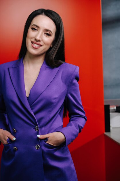 Mujer posando con un traje morado de pie con las manos en los bolsillos