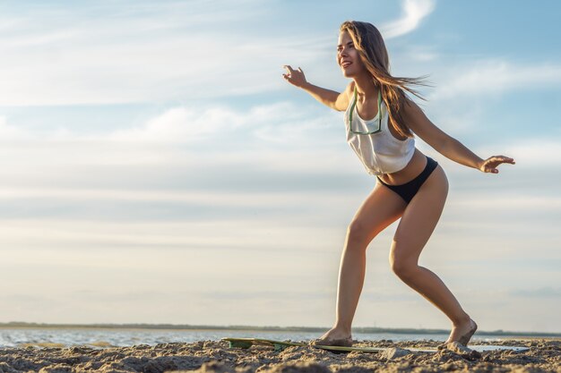 Una mujer practica pararse en una tabla de surf