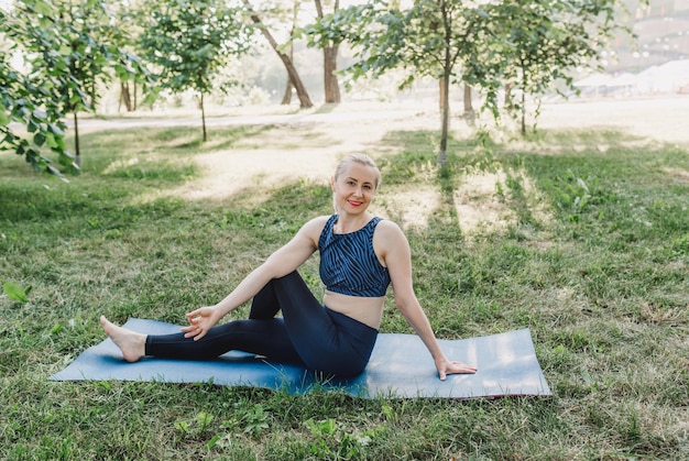 Una mujer practicando asanas de yoga al aire libre Una joven y atractiva chica fitness esbelta en un mono relaxe
