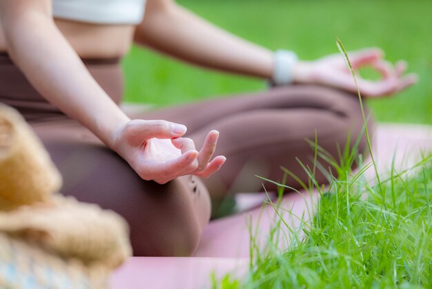 Mujer practicando lección de yoga respirando meditando en un parque al aire libre