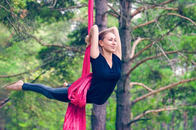 Mujer practicando yoga aéreo o antigravedad