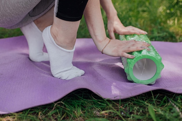 Mujer practicando yoga y meditando al aire libre Chica preparando material para la clase de práctica en el jardín Felicidad femenina y concepto de yoga Durante la cuarentena debido a la propagación del coronavirus