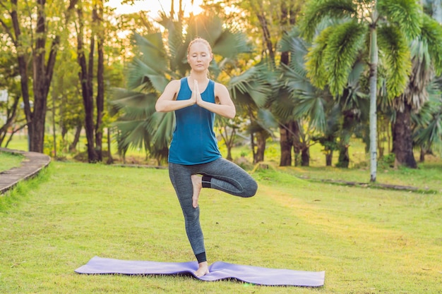 Mujer practicando yoga en un parque tropical