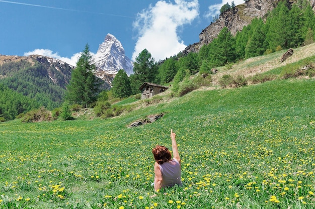 Mujer en un prado en el fondo del Matterhorn Suiza