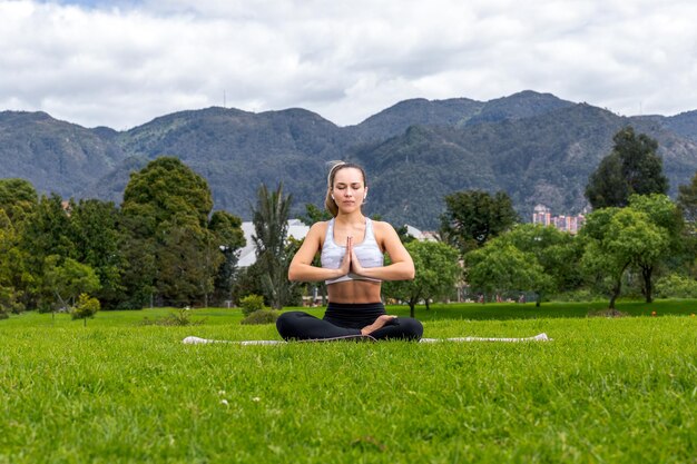 mujer praticando yoga en el parque al aire libre