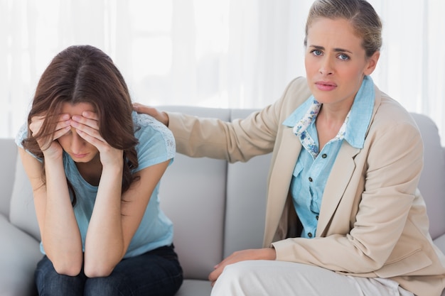 Foto mujer preocupada siendo consolada por su terapeuta comprensivo