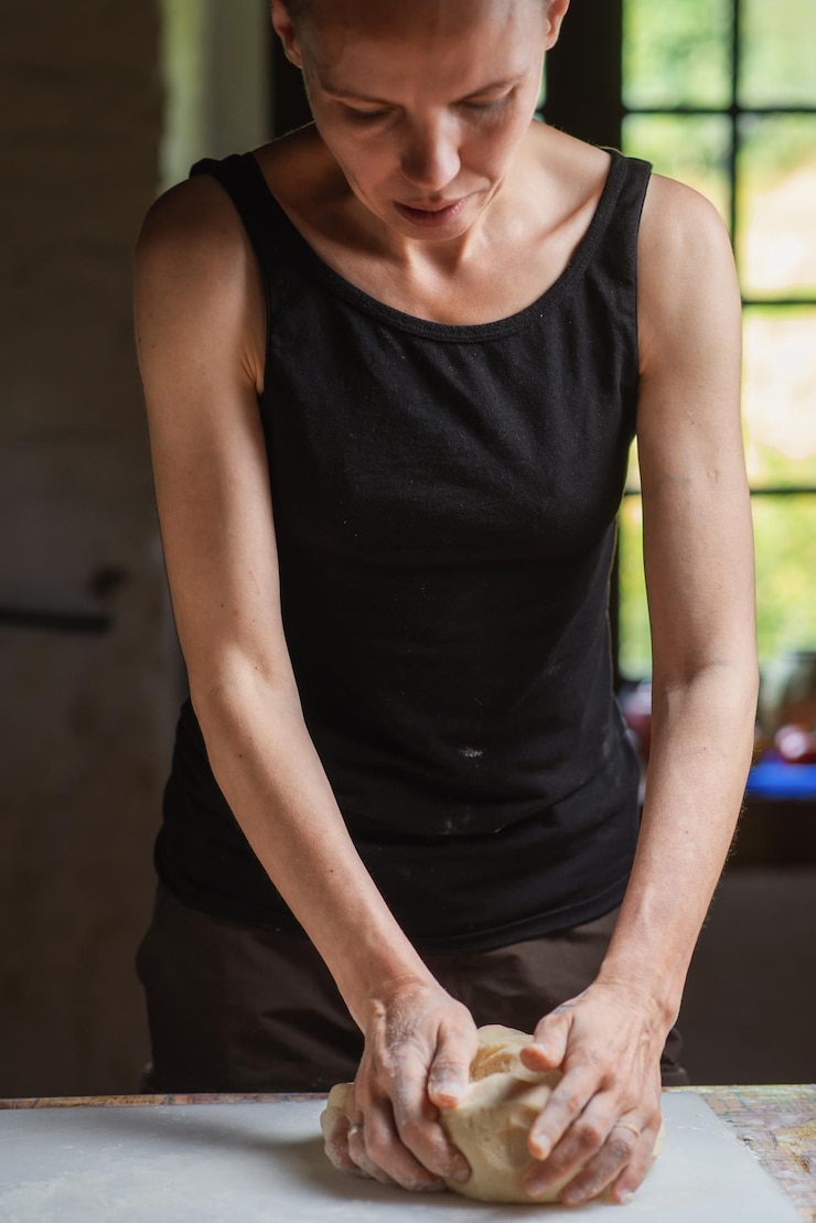 Foto mujer prepara masa en la cocina mujer calva preparándose para pizza de pan