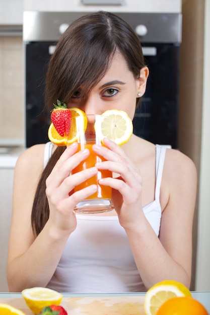 Mujer prepara un zumo de fruta con exprimidor.