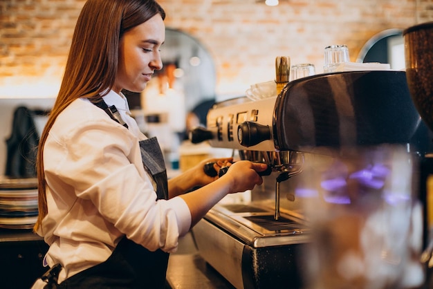 Mujer preparando café en una cafetería.