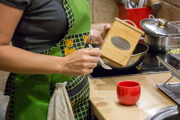 Mujer preparando café de la mañana en la cocina