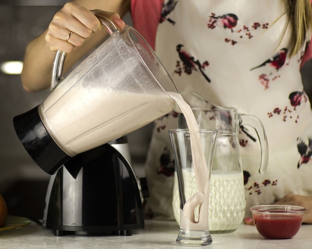 Mujer preparando un cóctel de leche