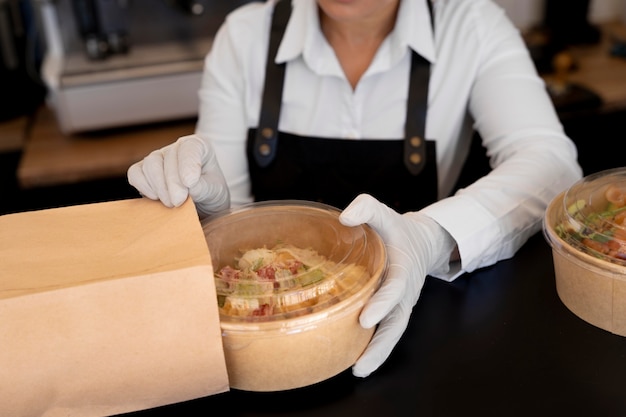 Mujer preparando comida para llevar para entregar