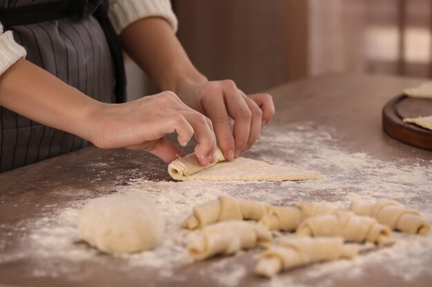 Mujer preparando croissants en mesa