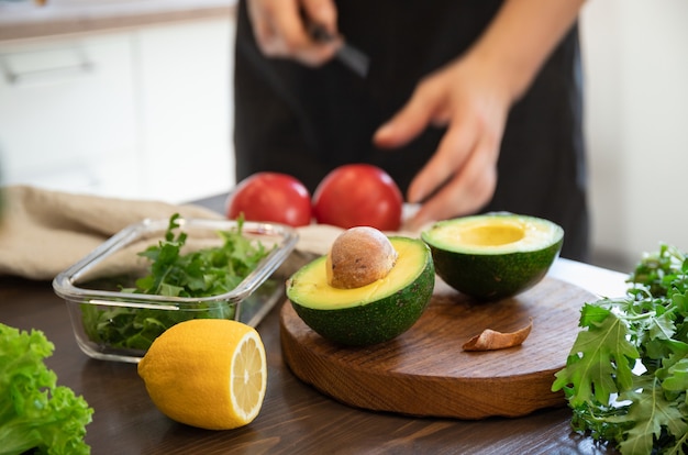 Foto la mujer está preparando ensalada de verduras en la cocina. comida sana. ensalada vegana. dieta. prepara comida.