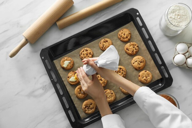 Mujer preparando galletas en la vista superior de la mesa de mármol blanco Cocinando comida deliciosa