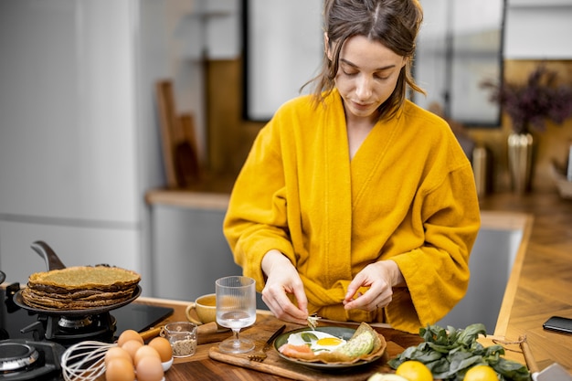 Mujer preparando huevos para el desayuno