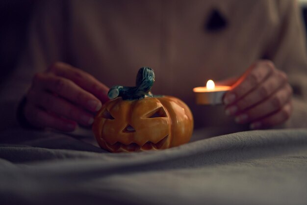 Mujer preparando jack o lantern de cerámica para la celebración de halloween