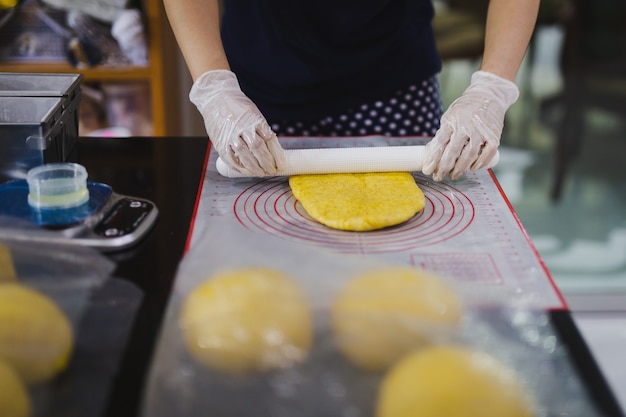 Mujer preparando masa de pan en la mesa de la cocina