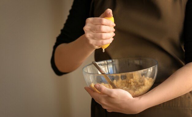 Mujer preparando masa para tarta de queso en la cocina