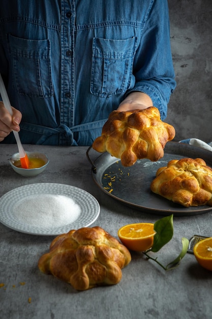 Mujer preparando Pan de muertos pan de muertos para el día mexicano de los muertos