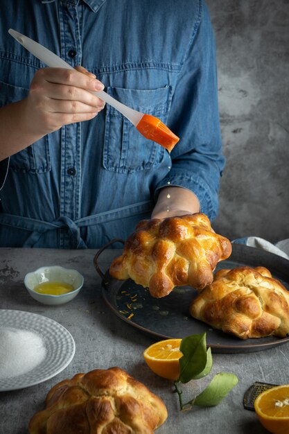 Mujer preparando Pan de muertos pan de muertos para el día mexicano de los muertos