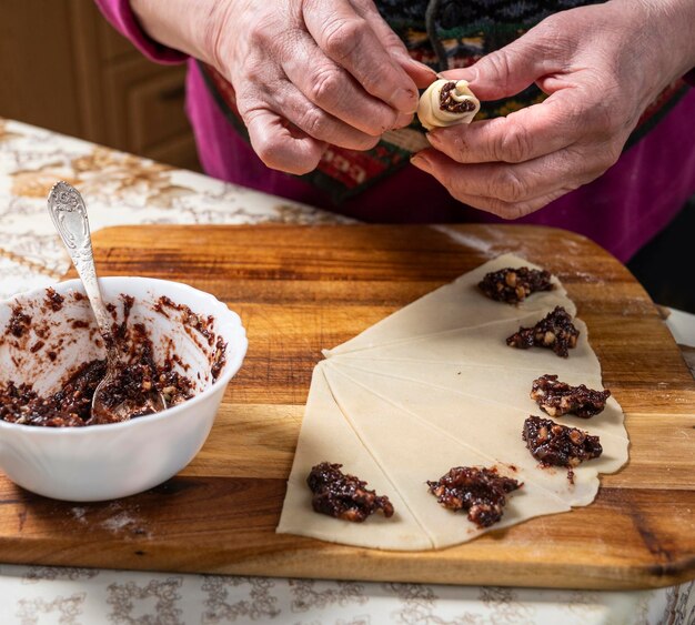 Mujer preparando panecillos caseros con mermelada en casa