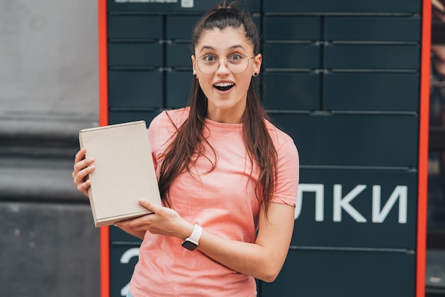 Mujer preparando el paquete para su envío al cliente cerca de la oficina de correos