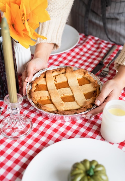 Mujer preparando pastel de calabaza para la cena de acción de gracias en la cocina de casa