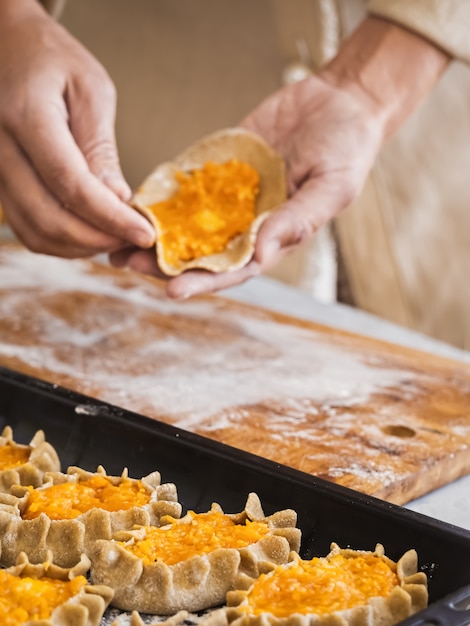 Mujer preparando pasteles pirakka de Carelia