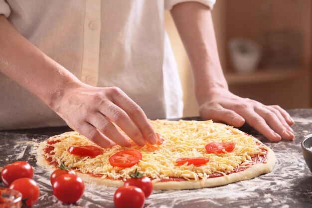 Mujer preparando pizza en la mesa de la cocina