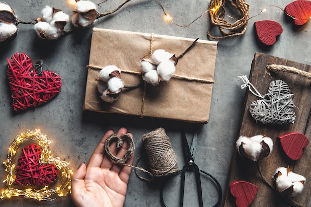 Mujer preparando regalo para envolver para el día de San Valentín