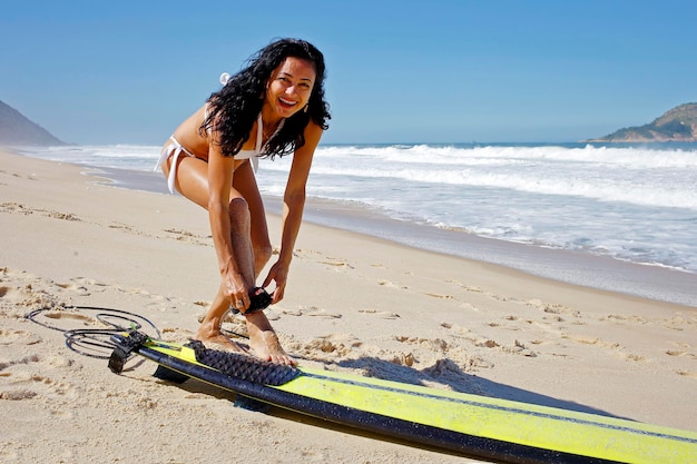 Mujer preparándose para surfear en Río de Janeiro.