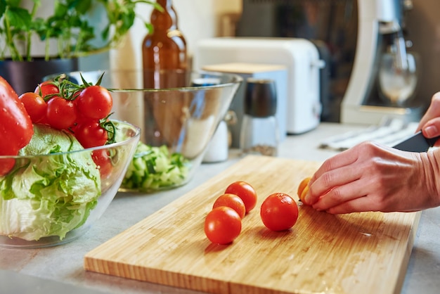 Mujer preparar ensalada con tomate cherry