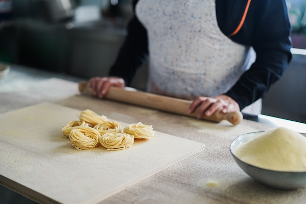 Mujer preparar pasta tradicional dentro de la fábrica italiana