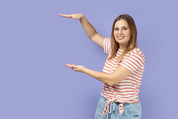 Mujer presentando el área entre las manos para un anuncio que muestra un tamaño enorme